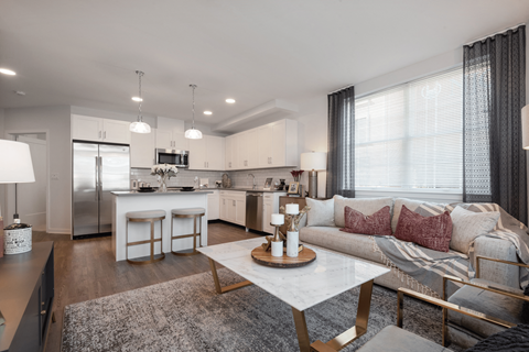 a living room and kitchen with a couch and a table
